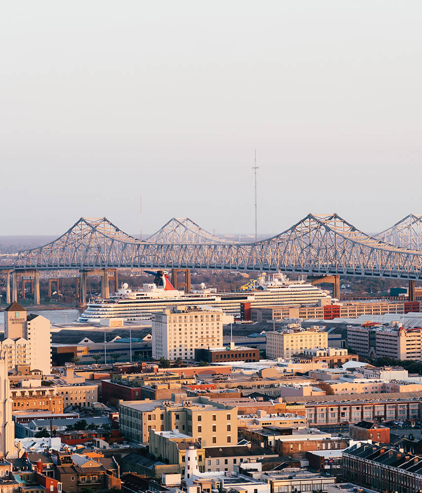 The sun sets over the skyline of downtown New Orleans