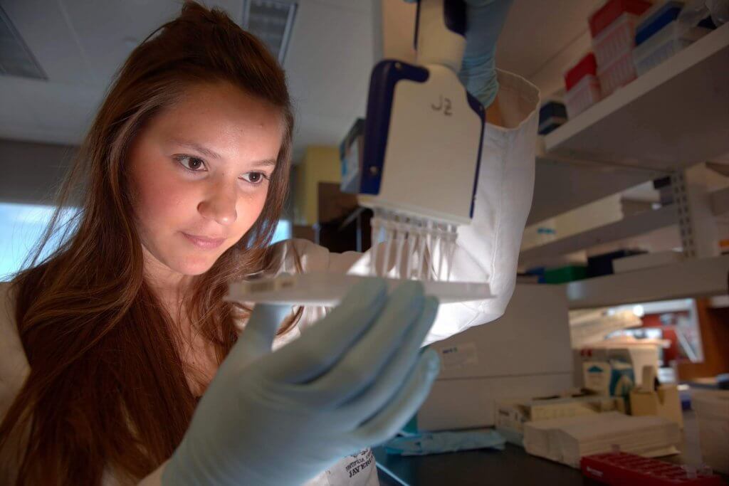 Young woman studying her findings at the Louisiana Cancer Research Center