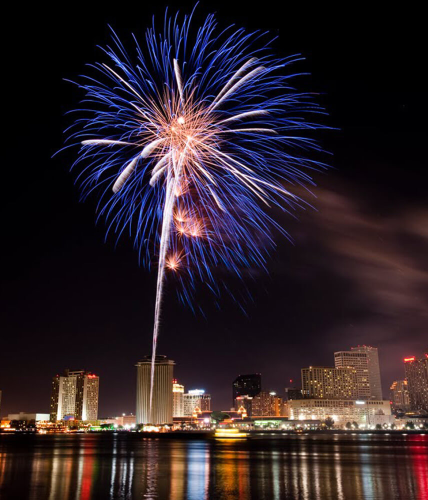 Fireworks extend high over the skyline of downtown New Orleans at night