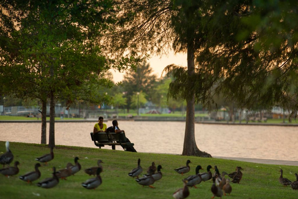 People sit on a bench in a park in New Orleans, LA